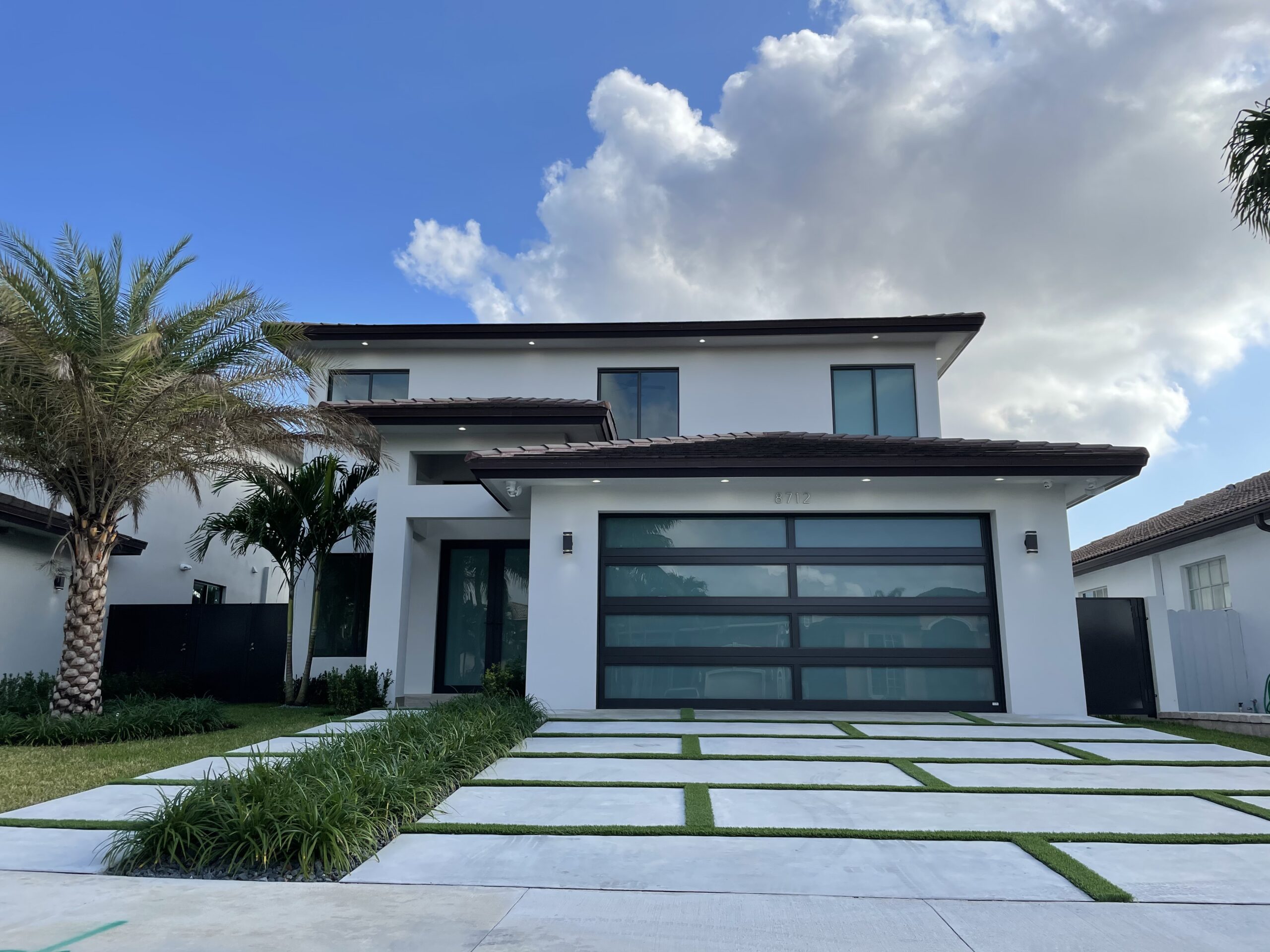 Window installation in Miami, FL — black-framed windows on a two-story home
